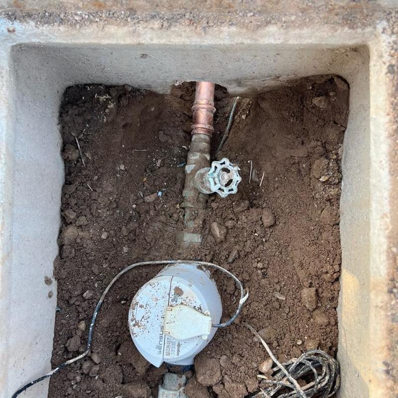 Water main valve and meter box installation in dirt hole
