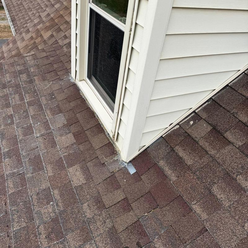 Roof shingles with hail damage near dormer window