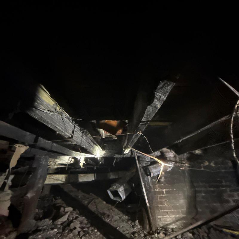 Roof support beams with fire damage in crawl space