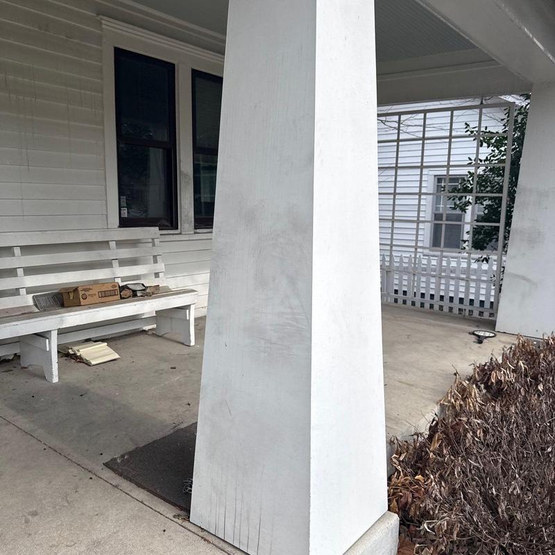 Concrete porch column with surface wear and cracks