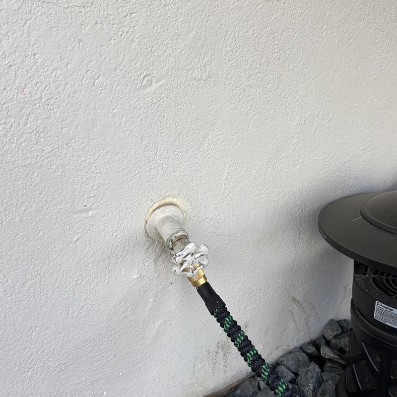Outdoor water spigot with attached garden hose