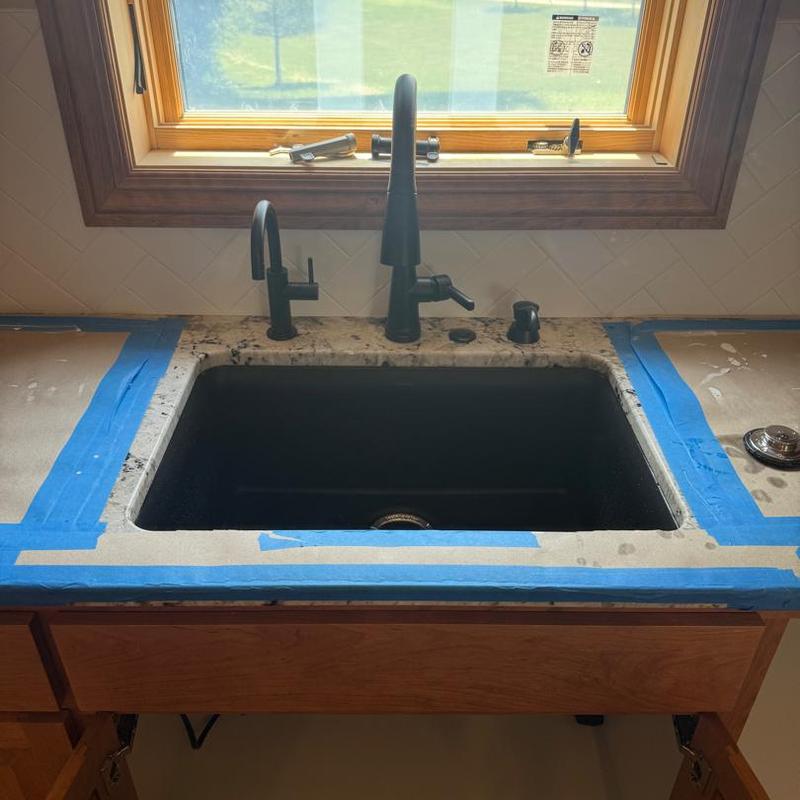 Black kitchen sink with matte black faucets installation