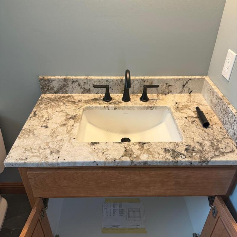Bathroom sink with granite countertop and black faucet