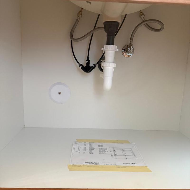 Kitchen sink plumbing and fixture installation under cabinet