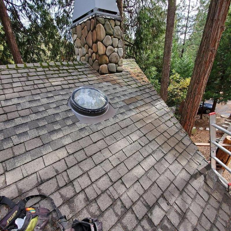 22-inch sun tunnel installed on shingle roof near chimney