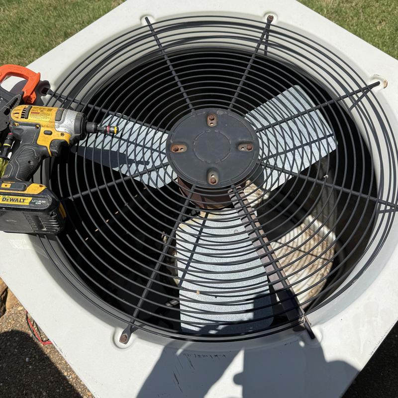 Air conditioner condenser fan with cordless drill on top Air conditioner condenser fan with cordless drill on top