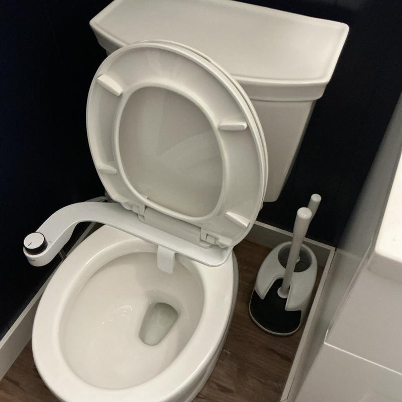 Toilet bowl with open lid and bidet attachment Toilet bowl with open lid and bidet attachment