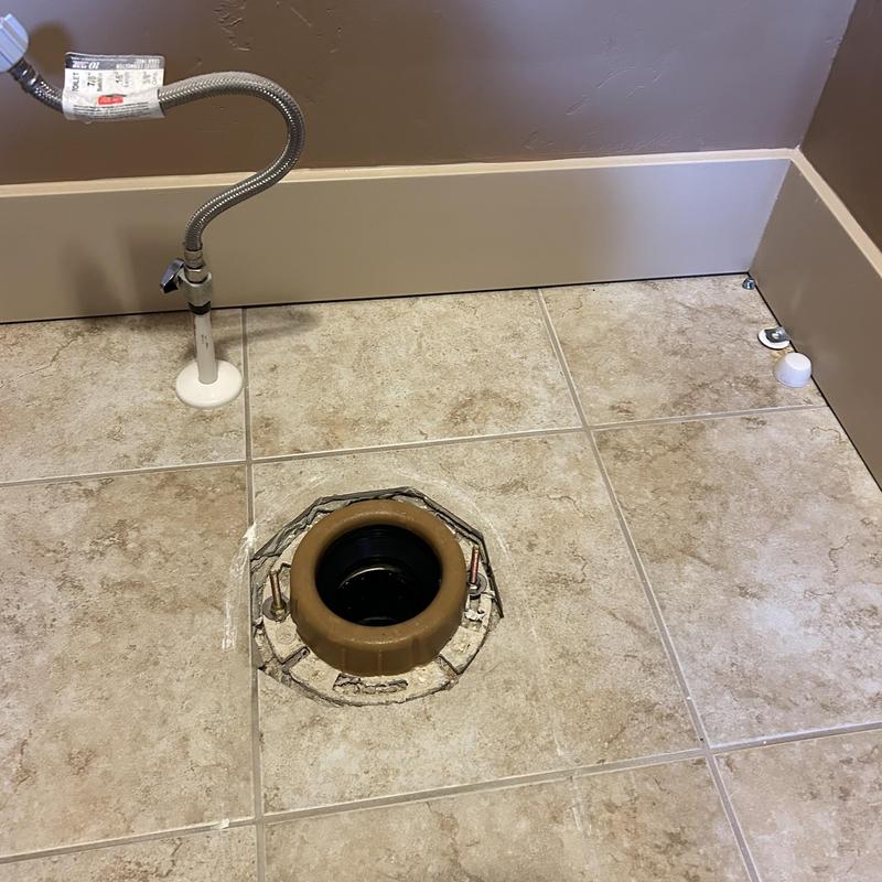 Toilet flange and water supply line in bathroom floor