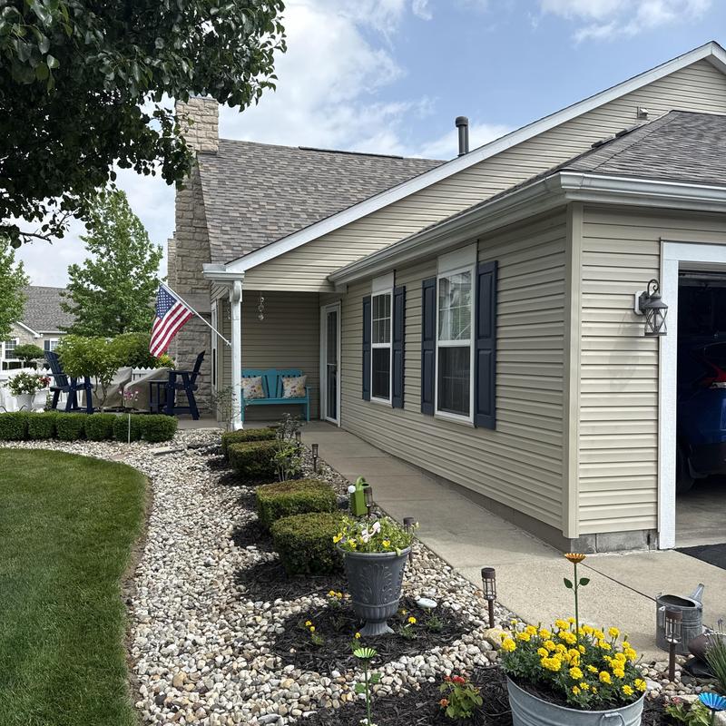Gutters on condo exterior with landscaping and walkway