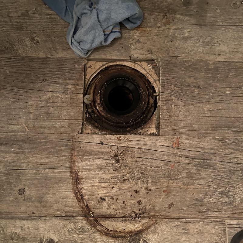 Toilet flange with removed toilet on wood floor Toilet flange with removed toilet on wood floor