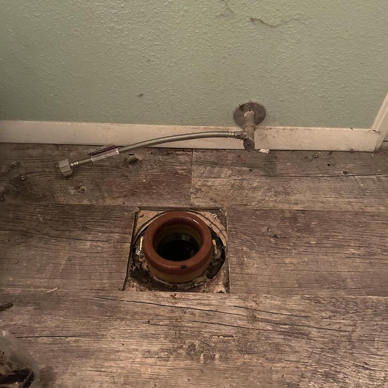 Toilet flange and water supply line on wood floor Toilet flange and water supply line on wood floor