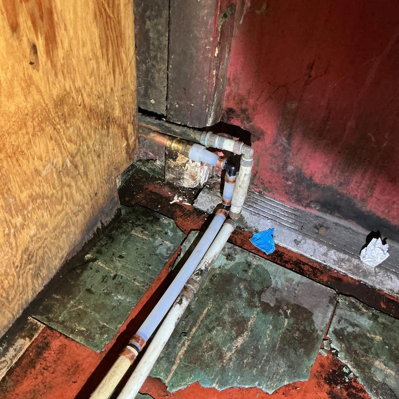 Copper water piping with repair fittings in basement corner Copper water piping with repair fittings in basement corner
