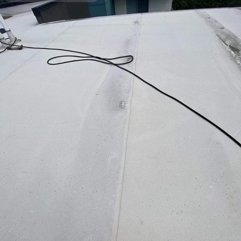 Flat roof surface with cleaning residue and drainage line