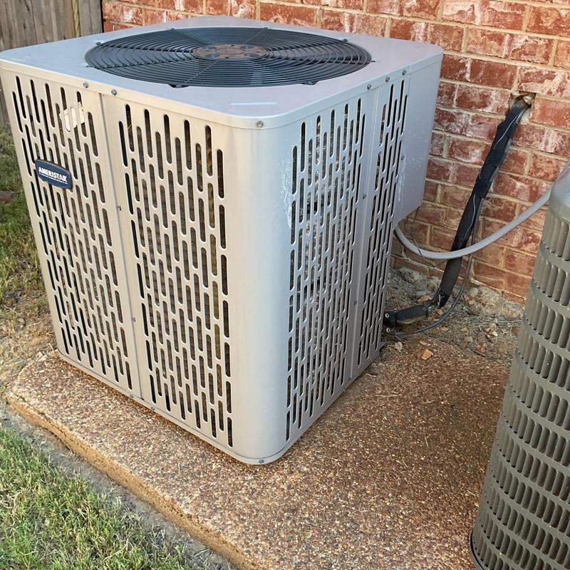 Air conditioner condenser unit next to brick wall outdoors Air conditioner condenser unit next to brick wall outdoors