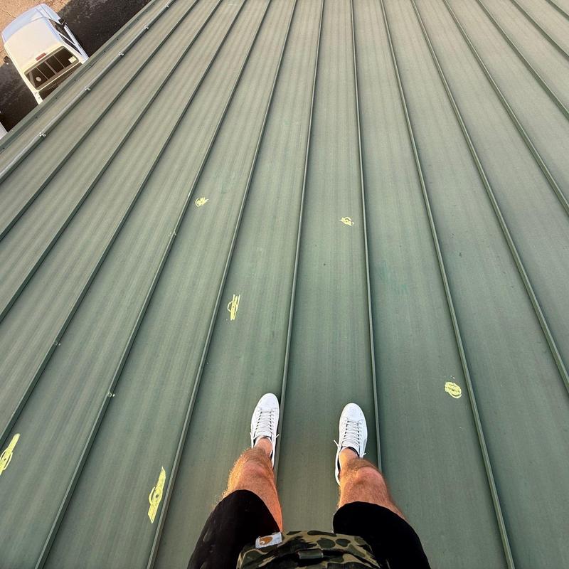Metal standing seam roof with marked hail damage spots