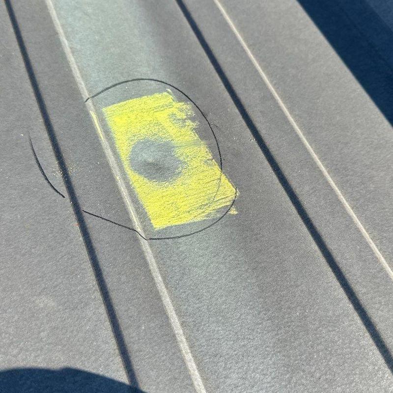 Metal roof hail damage marked for repair