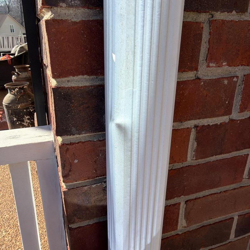 Metal downspout dent on brick wall background