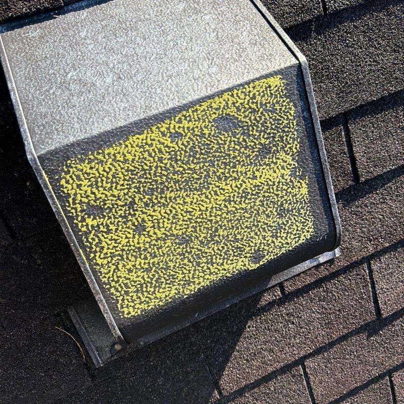 Roof vent with yellow hail damage markings on shingles