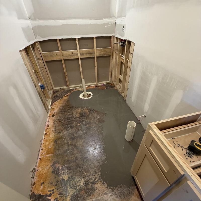 Bathroom floor with self-leveler application in progress