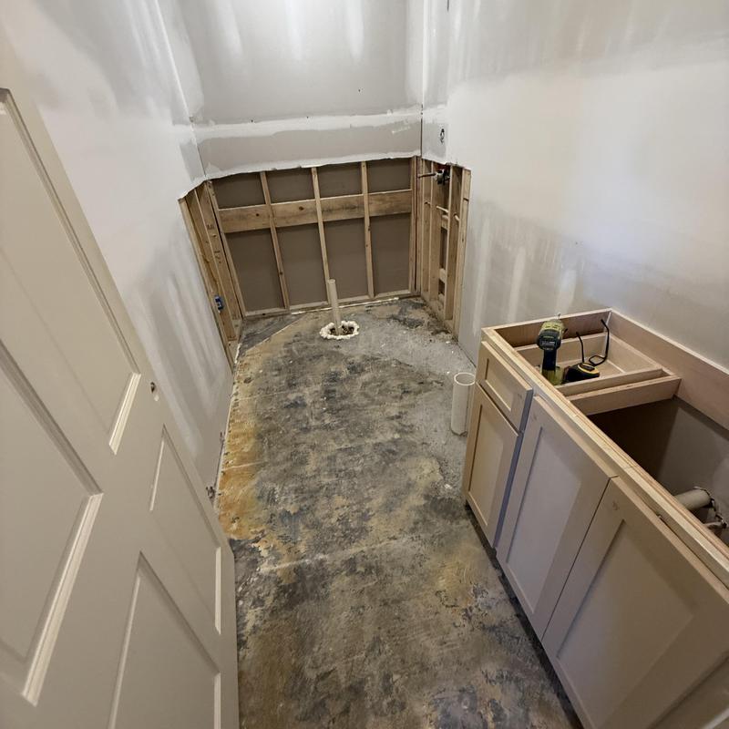 Bathroom floor with exposed subfloor and vanity installation