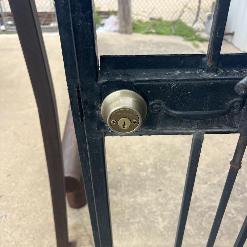 Double deadbolt lock on black metal gate