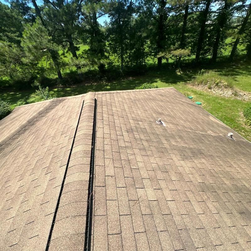 Asphalt shingle roof with ridge vent and vent pipes