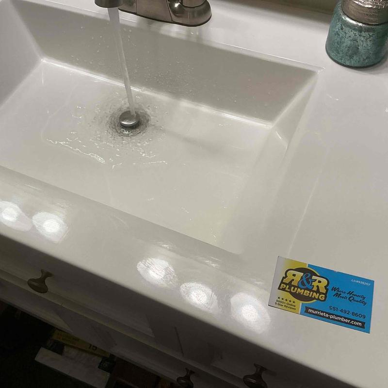 Bathroom sink pop-up drain with running faucet