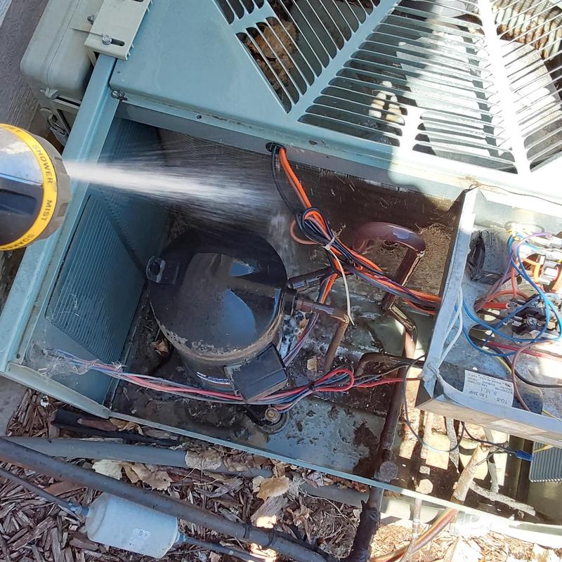 Carrier air conditioner compressor being cleaned with spray