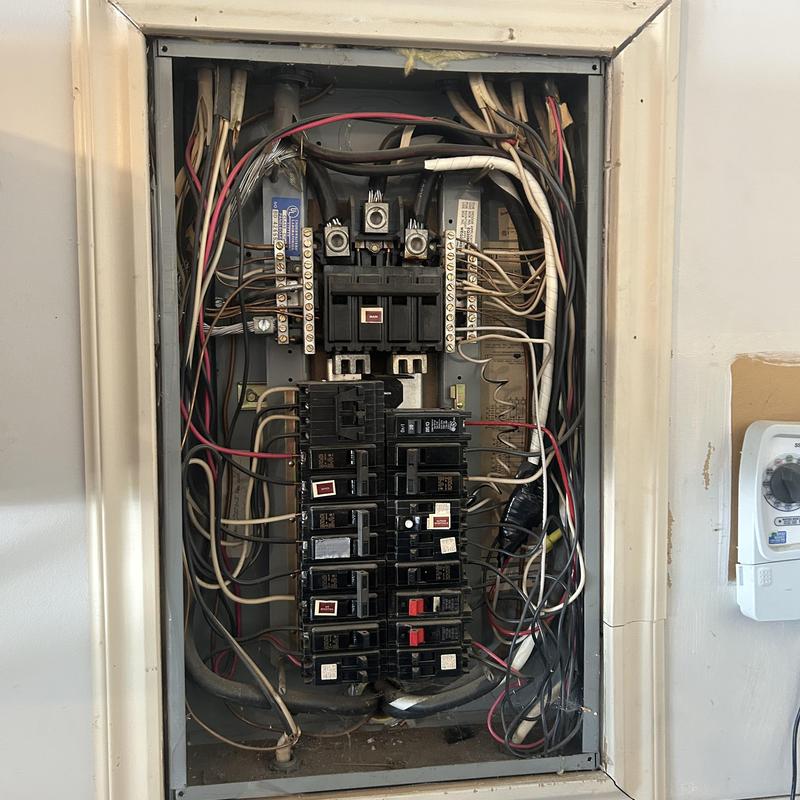 Electrical panel with breakers and wiring in garage