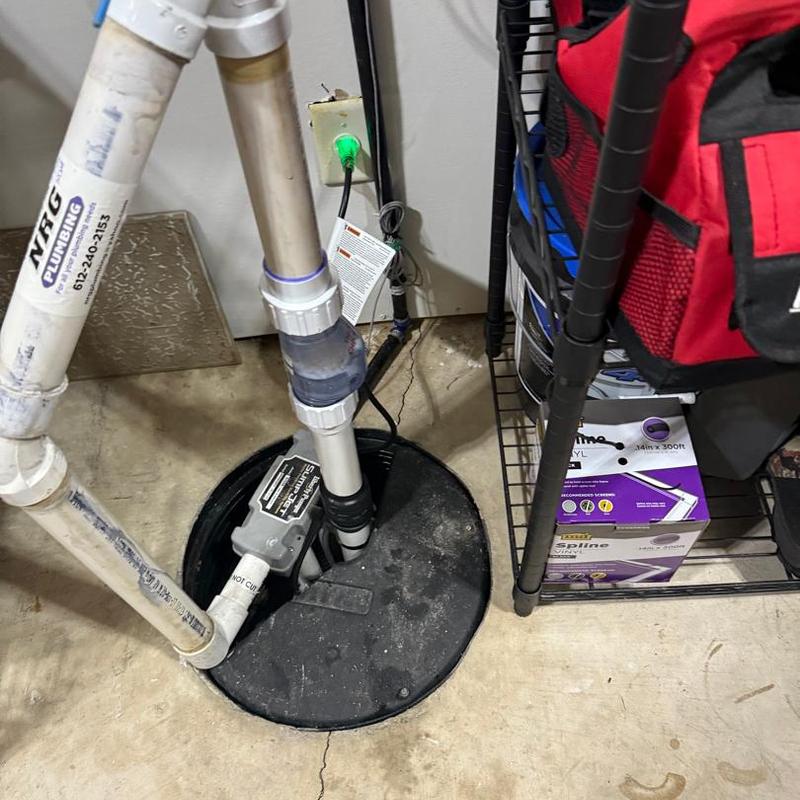 Sump pump with PVC piping in basement corner