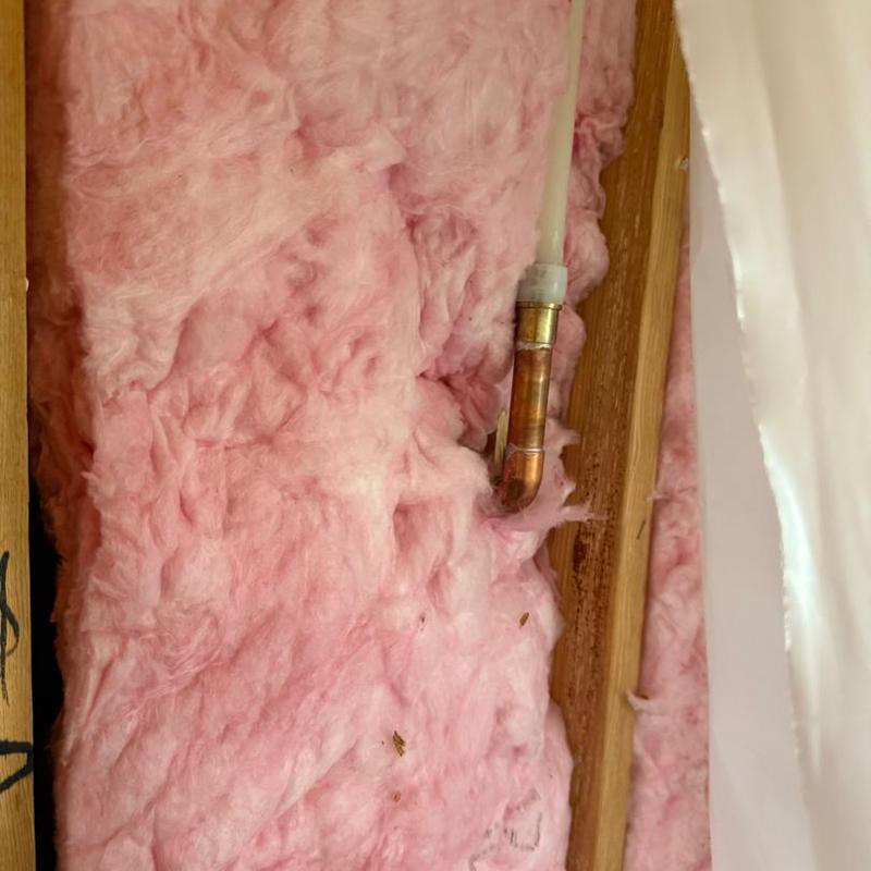 Copper plumbing pipe with fittings in pink insulation