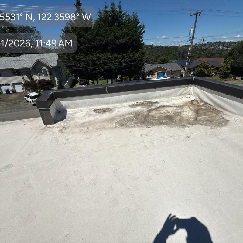 Flat roof membrane with damaged area near parapet wall