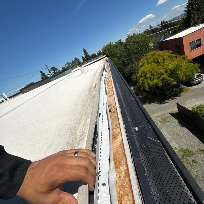 Roof edge flashing inspection on flat commercial roof