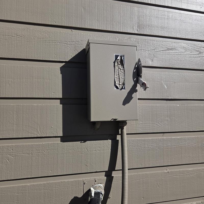 Electrical disconnect box with damaged cover on siding Electrical disconnect box with damaged cover on siding