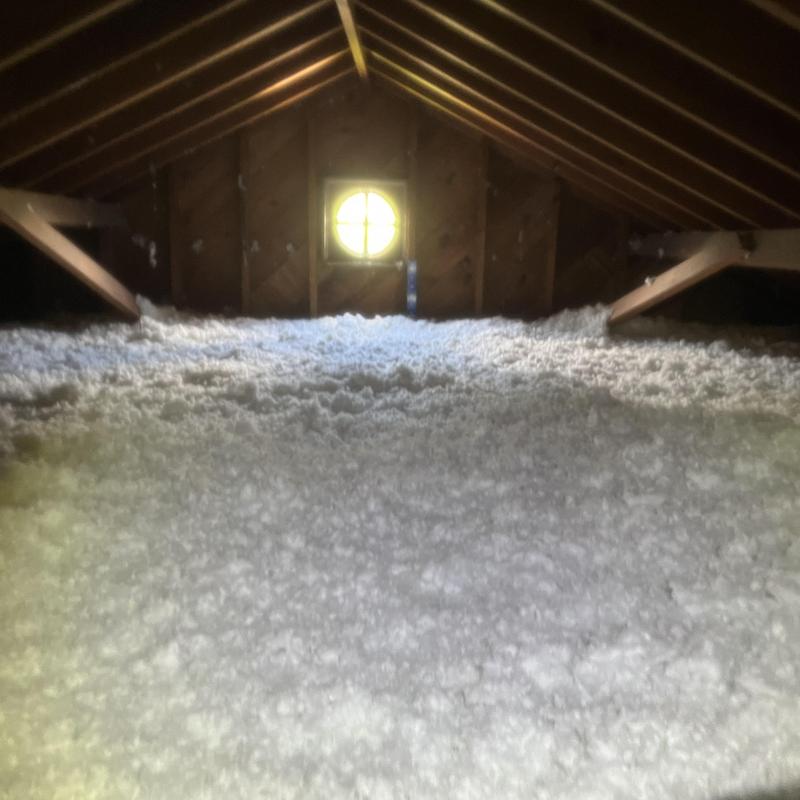Attic insulation blown-in layer in wooden attic space