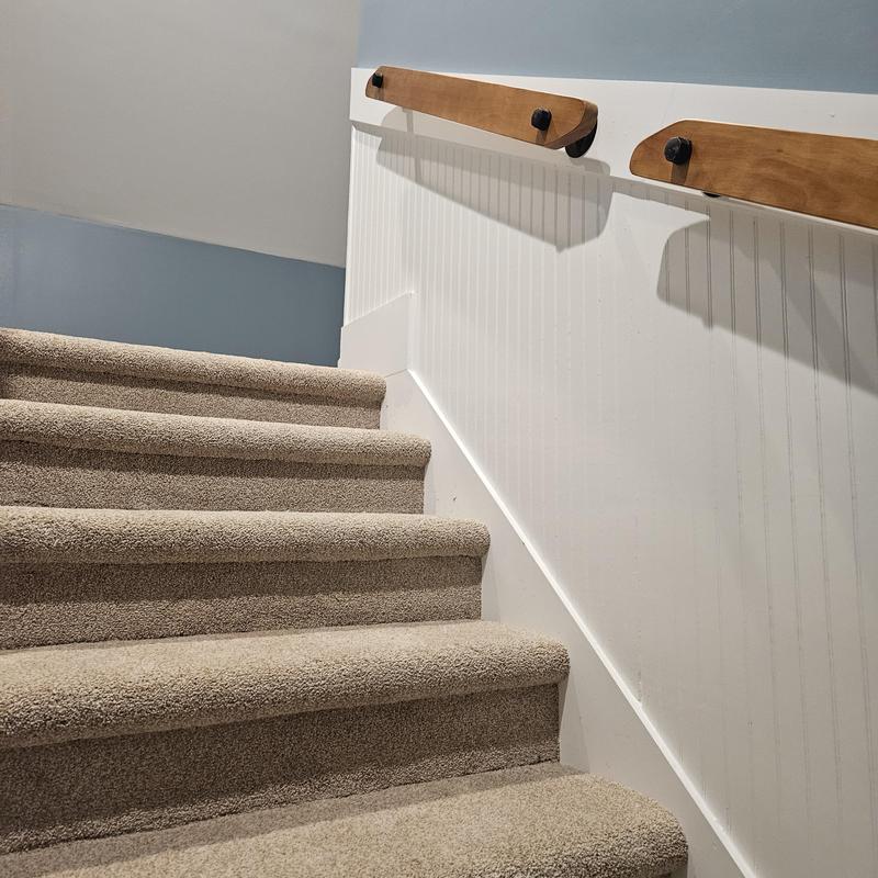 Carpeted stairs with wooden handrails and beadboard wall paneling Carpeted stairs with wooden handrails and beadboard wall paneling