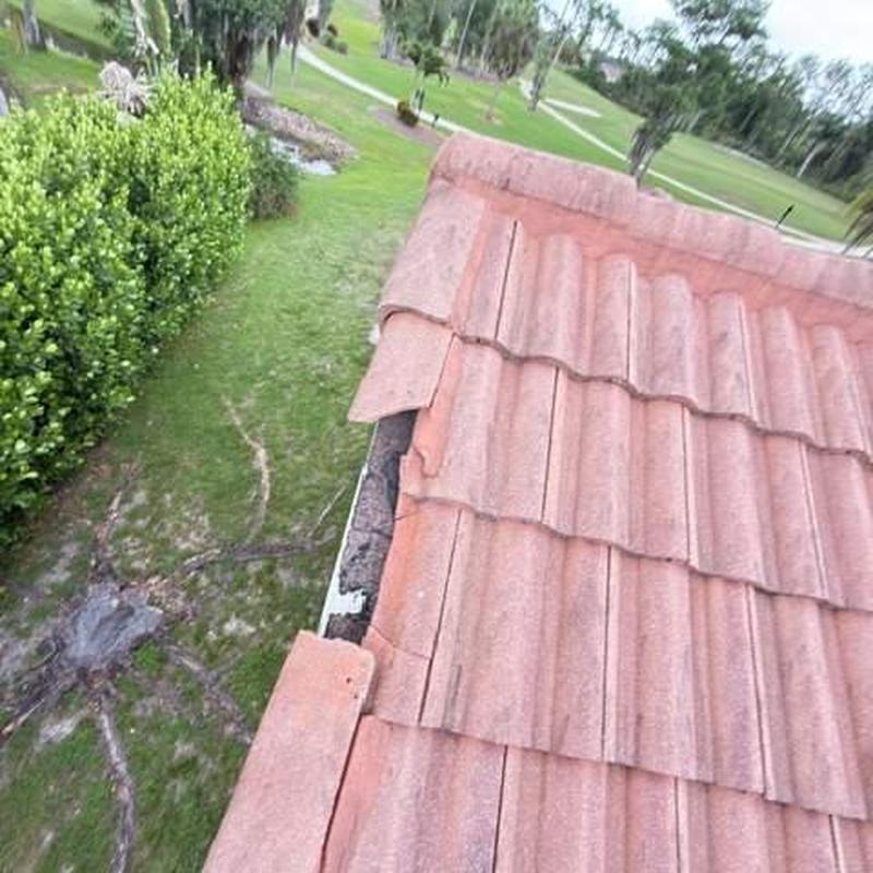Concrete tile roof with damaged edge tiles and gutter line
