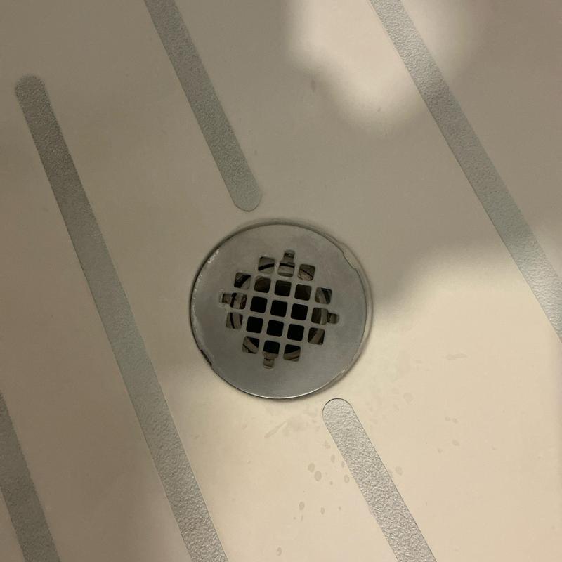 Shower drain on floor with metal grate and water spots Shower drain on floor with metal grate and water spots