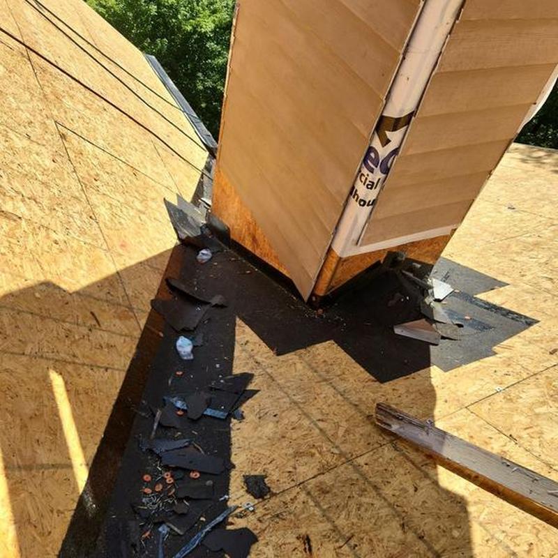 Roof chimney flashing with removed shingles and wood decking