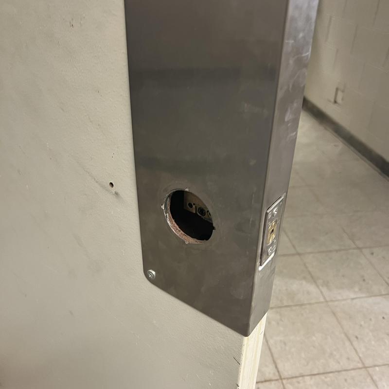 Deadbolt lock housing on metal door frame in basement