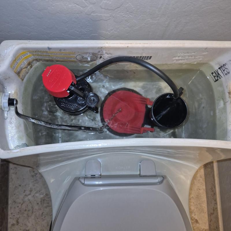 Toilet tank fill valve and flapper assembly inside tank