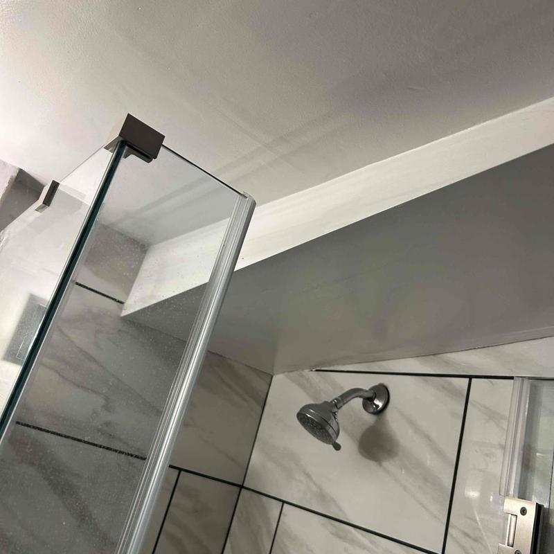 Shower valve and glass enclosure in tiled bathroom Shower valve and glass enclosure in tiled bathroom