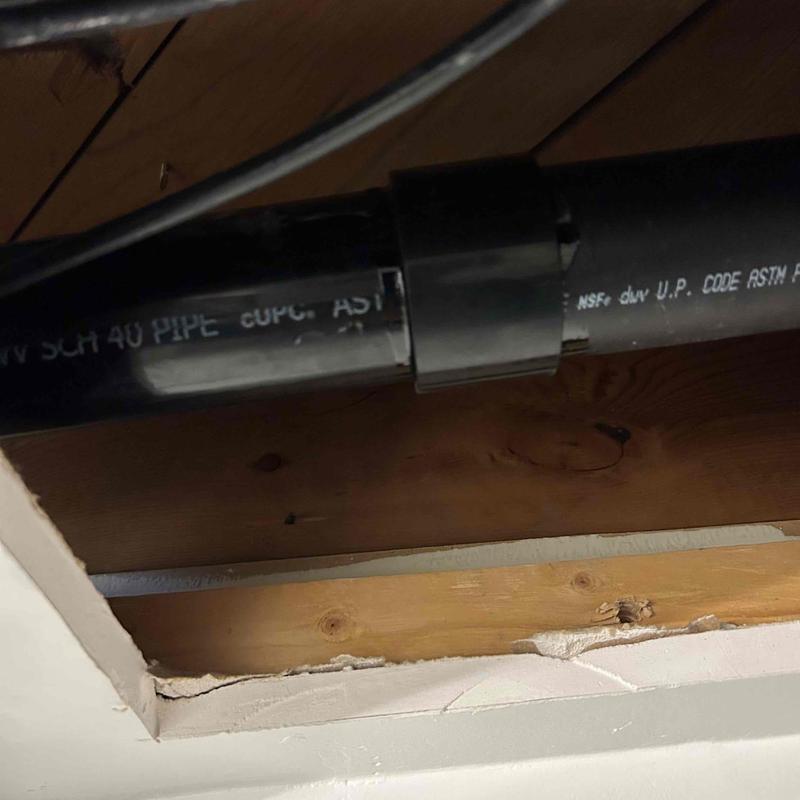 Black PVC waste and overflow pipe inside ceiling cavity Black PVC waste and overflow pipe inside ceiling cavity