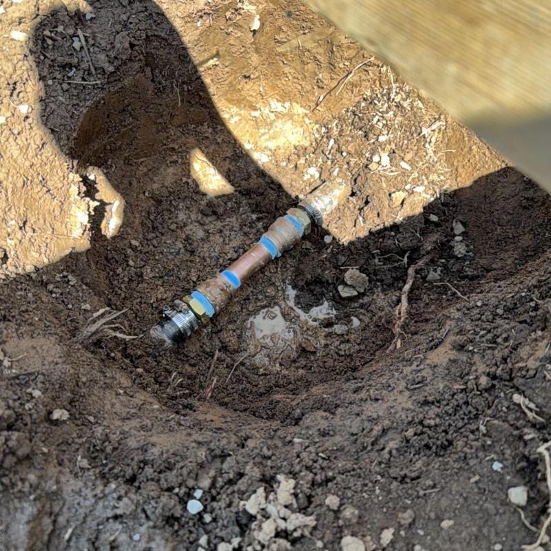 Copper water supply pipe with fittings in soil trench