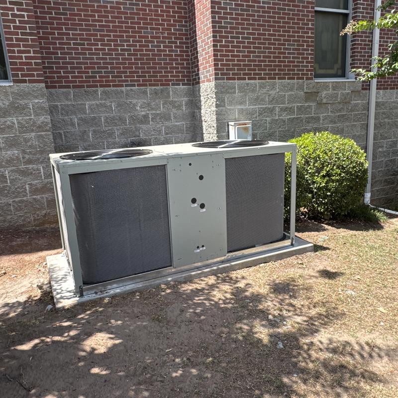 Commercial HVAC condenser unit outside brick building Commercial HVAC condenser unit outside brick building