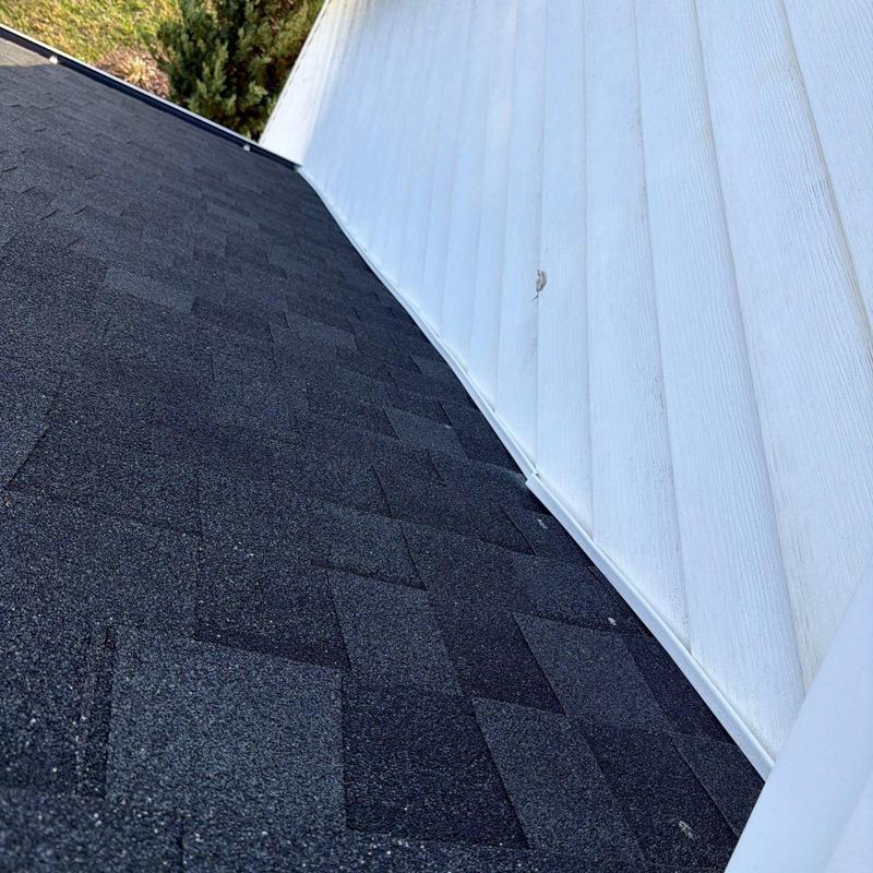 Asphalt shingle roof near white exterior wall