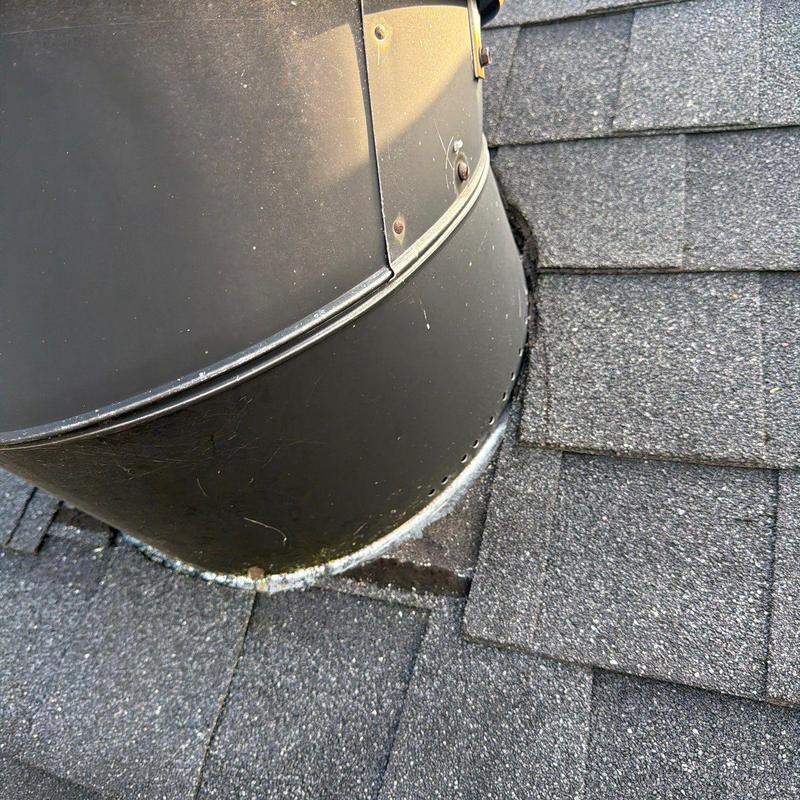 Roof vent flashing with damaged shingles and sealant.