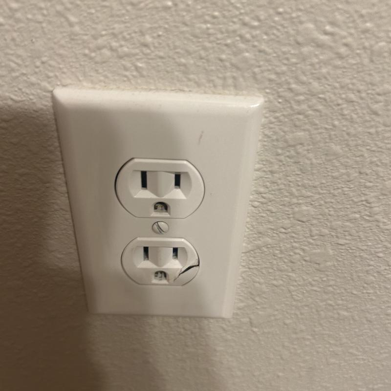 Damaged electrical receptacle with broken cover plate
