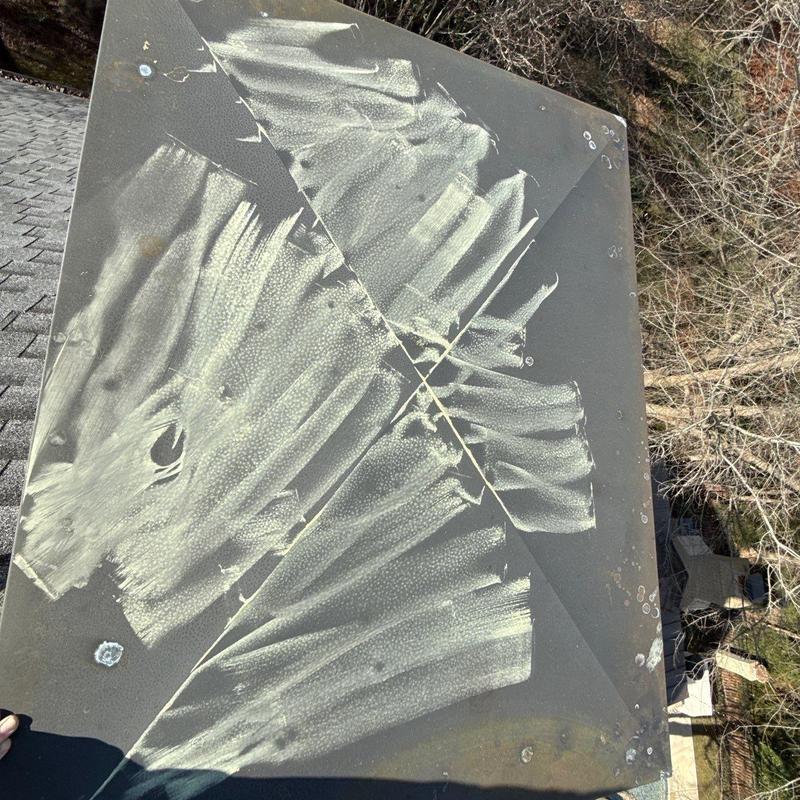 Metal roof vent with hail damage and impact marks