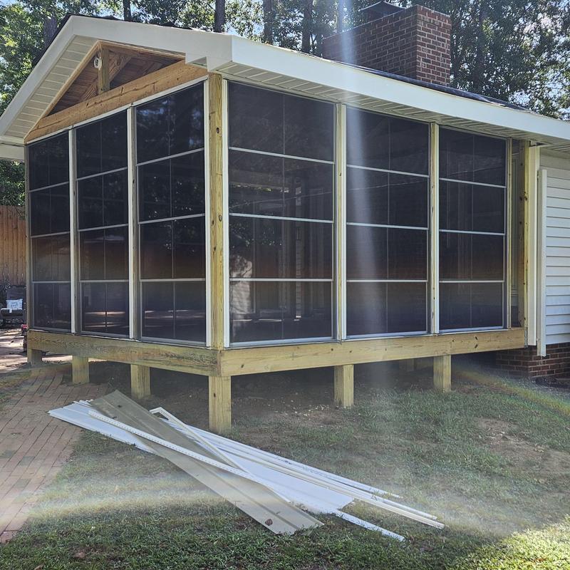 Screened porch enclosure with wood framing and brick chimney Screened porch enclosure with wood framing and brick chimney